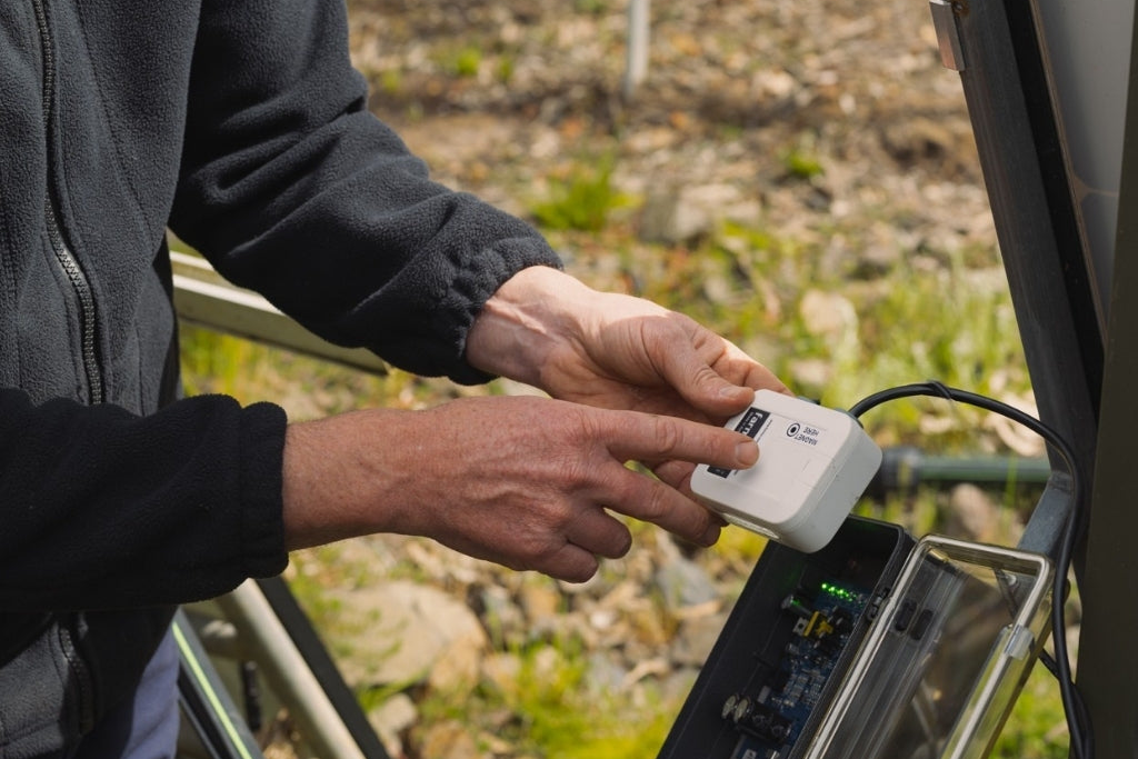 Person using a Farmo Automation device with a natural outdoor background